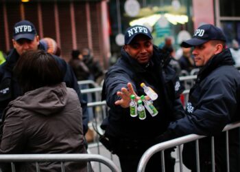 An NYPD officer with four small bottles of alcohol.