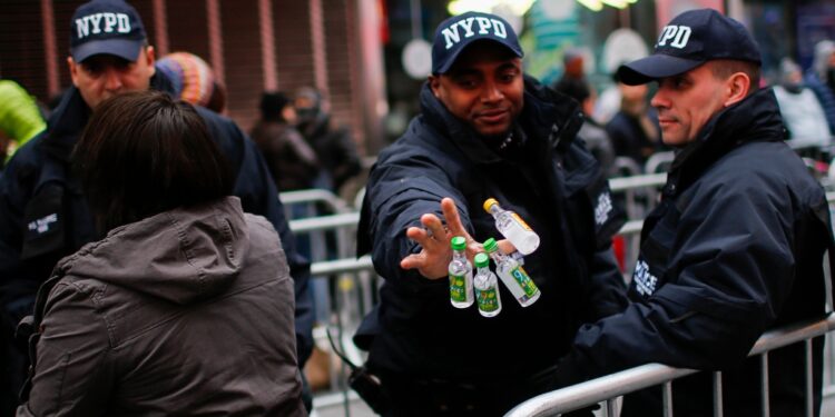 An NYPD officer with four small bottles of alcohol.