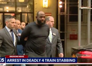 Claude White is led out of court in handcuffs by detectives.