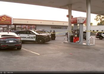 Police tape and police car outside of Houston gas station