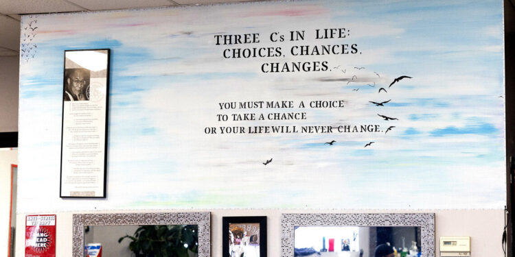 A mural inside a barbershop reads, “Three C’s in Life: Choices, chances, changes. You must make a choice to take a chance or your life will never change.”