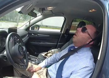 Matthew Reilly is pictured passed out in his car