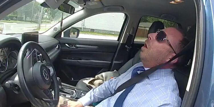 Matthew Reilly is pictured passed out in his car