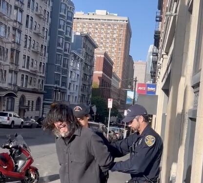 man on street getting handcuffed