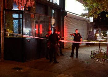 Police investigate at the taped-off scene outside Kama Restaurant & Lounge, where four men were shot -- one fatally --- early Monday.