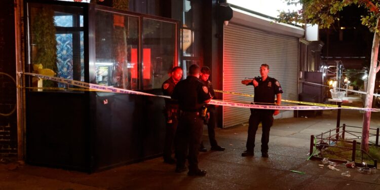 Police investigate at the taped-off scene outside Kama Restaurant & Lounge, where four men were shot -- one fatally --- early Monday.