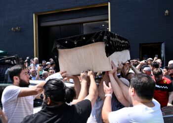 Mourners carry Faridun Mavlonov's casket at his Friday funeral.