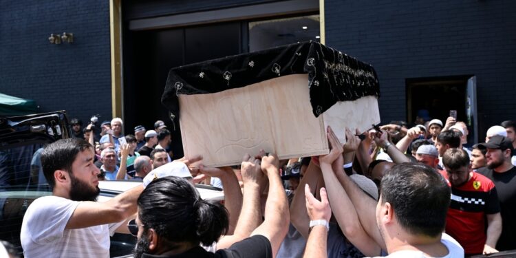 Mourners carry Faridun Mavlonov's casket at his Friday funeral.