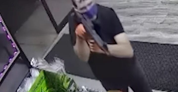 Surveillance footage of a man armed with a rifle robbing Veterans Convenience store in Staten Island on July 8, 2023.