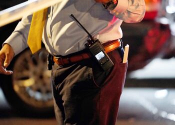 A general view of the handcuffs, gun holster, walkie talkie and badge on the belt of an NYPD detective at the scene where a five year old was reportedly shot on White Plains Road at E213rd Street in the Bronx, NY
