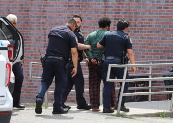Police walking with Abreu in cuffs.