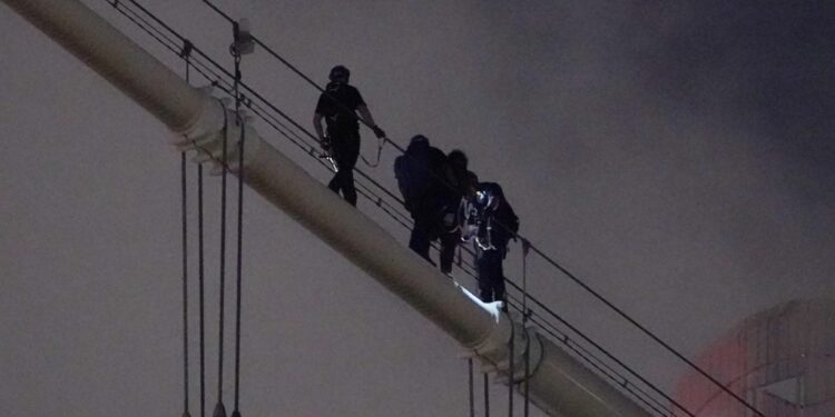Two people were taken into custody for climbing on the Manhattan Bridge Saturday night.