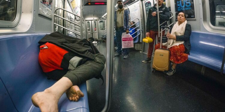 2 homeless sleeping on a Queens bound E train subway car.