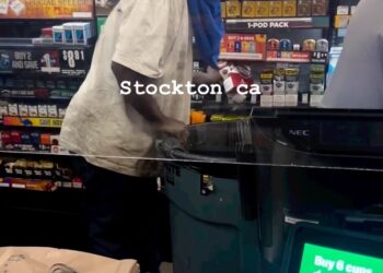 The man loads his garbage bin.