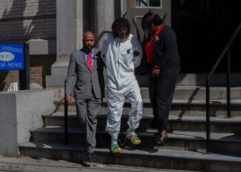 Shawn Rivera is walked from the 108th Precinct in Long Island City.