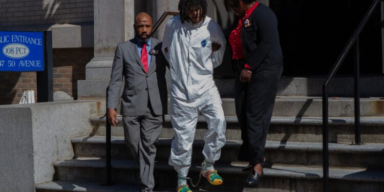 Shawn Rivera is walked from the 108th Precinct in Long Island City.