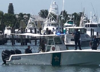 Palm Beach Sheriff's deputies stand onboard a Sheriff's Office boat.