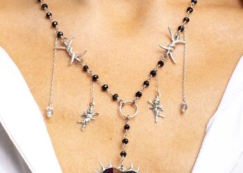 A necklace named for Amber Lynn Costello featuring angels and a big stone and thorns on a model.