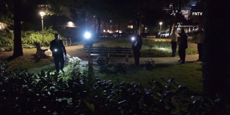 Detectives investigate the scene where a female panhandler was raped in a church courtyard in Chelsea.