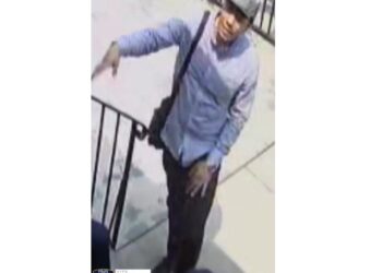 A man in a button-down shirt suspected in a heist is seen in a surveillance photo