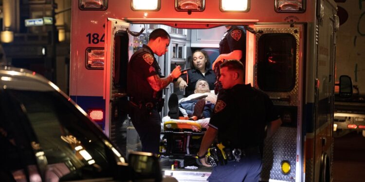 Police officers and EMS are seen treating a man who was stabbed in the head and stomach at 500 5th Ave. in Manhattan.