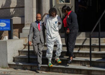Shawn Rivera is seen being walked out of the precinct