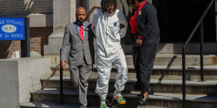 Shawn Rivera is seen being walked out of the precinct