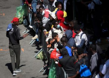 ecently arrived migrants to New York City wait on the sidewalk outside the Roosevelt Hotel