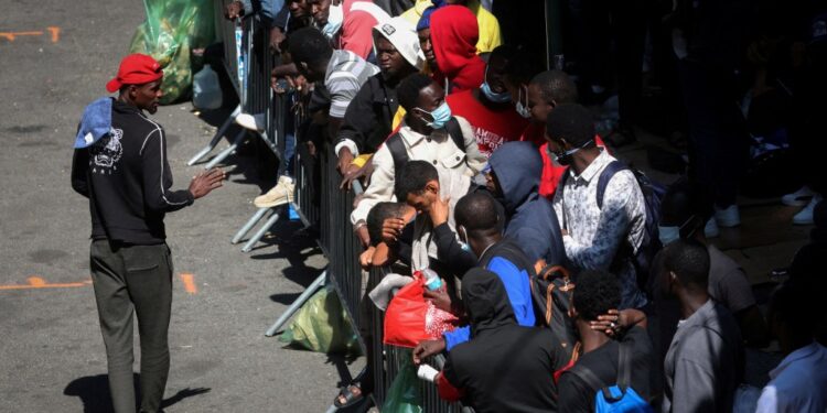 ecently arrived migrants to New York City wait on the sidewalk outside the Roosevelt Hotel