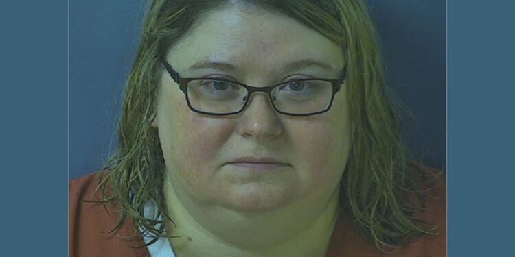 Mugshot of Heather Pressdee, wearing glasses and orange clothes.