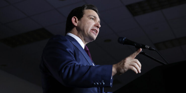 Florida Gov. Ron DeSantis, a White man, points a finger while giving a speech.