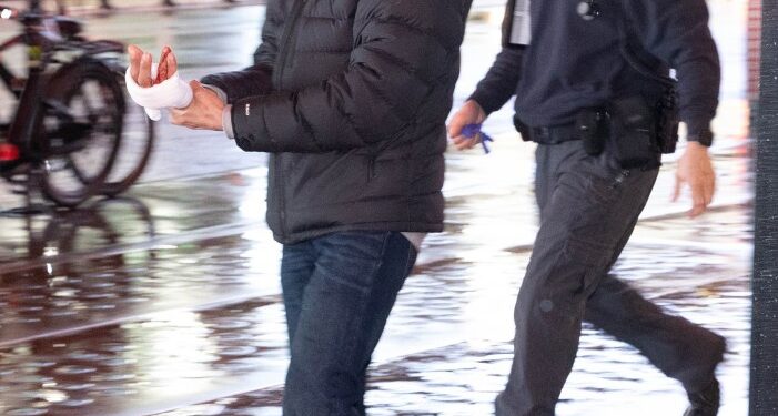 A man who was slashed in the hand in the subway at 42nd St.  Monday, Jan. 29, 2024, walks to an ambulance for treatment.