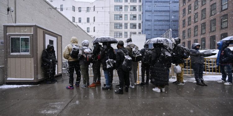 NYC Migrants. Friday, January 19, 2024 PICTURED: Migrants seen awaiting to be admitted into a Men's Migrant Super Center on Hall street in Brooklyn. The shelter houses around 2000 migrants.