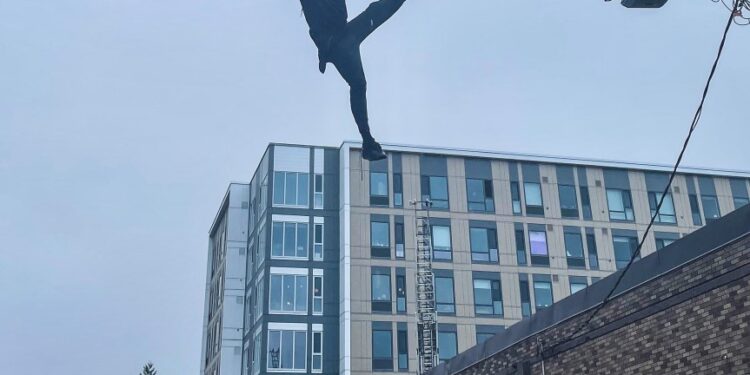 The suspect was dangling from a 20-foot cable before he dropped down on to a Washington state fire truck.