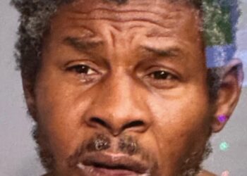 Man with a beard, identified as Alvin Doris, following two young boys selling candy on a subway platform at Broadway-Lafayette station.