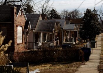 Brick houses line a road.