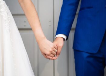 Wedding bride and bridegroom holding hands