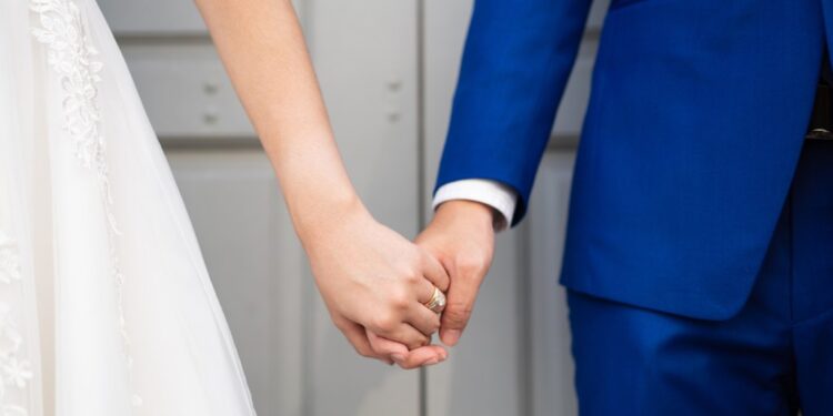 Wedding bride and bridegroom holding hands