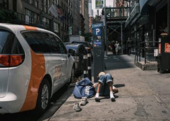 A person lying on the sidewalk next to a BRC van outside the Housing Works harm reduction center in midtown Manhattan.