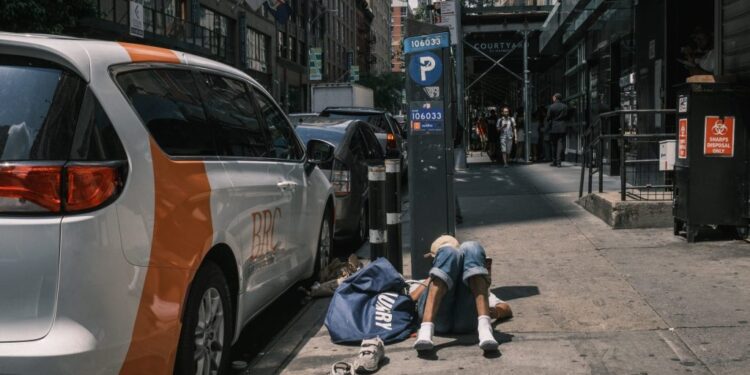 A person lying on the sidewalk next to a BRC van outside the Housing Works harm reduction center in midtown Manhattan.
