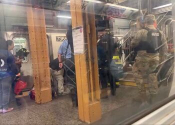 photo of EMTs helping victim at train station