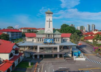 Building with a tower and a cross on top, representing St Joseph's Church where a priest was stabbed during Mass