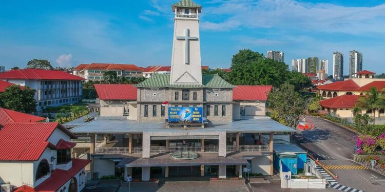 Building with a tower and a cross on top, representing St Joseph's Church where a priest was stabbed during Mass