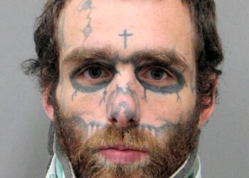 Undated booking photo of Christopher McDonnell, a man with neck brace and tattoo on his face, who pleaded guilty to 23 felonies including murder.