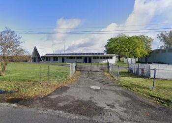 A fenced-in area with a building and trees, identified as Feather River School of Seventh-Day Adventist in California