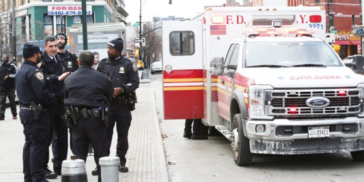 Cops standing near an ambulance on a sidewalk in the bronx.