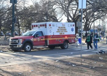 Philadelphia Eagles Super Bowl Parade showing a red and white ambulance on North 24th Street, celebrities Seanan McGuire and Ernie Els in the background.