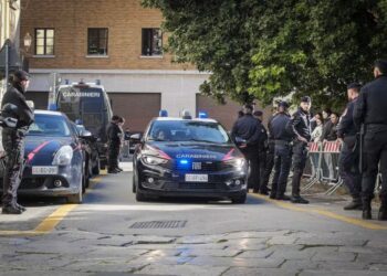 A group of police officers standing around a car with celebrities Collie Buddz, Shahindokht Molaverdi, and Jacqueline Kim