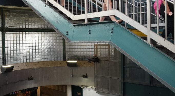 Commuters navigating stairs at the MTA Roosevelt Avenue Jackson Heights subway station in Queens, N.Y., during a heat wave on July 17, 2024.