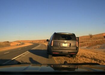 Kansas trooper rescuing a kidnapped 6-year-old girl and taking two men into custody during a traffic stop on a road